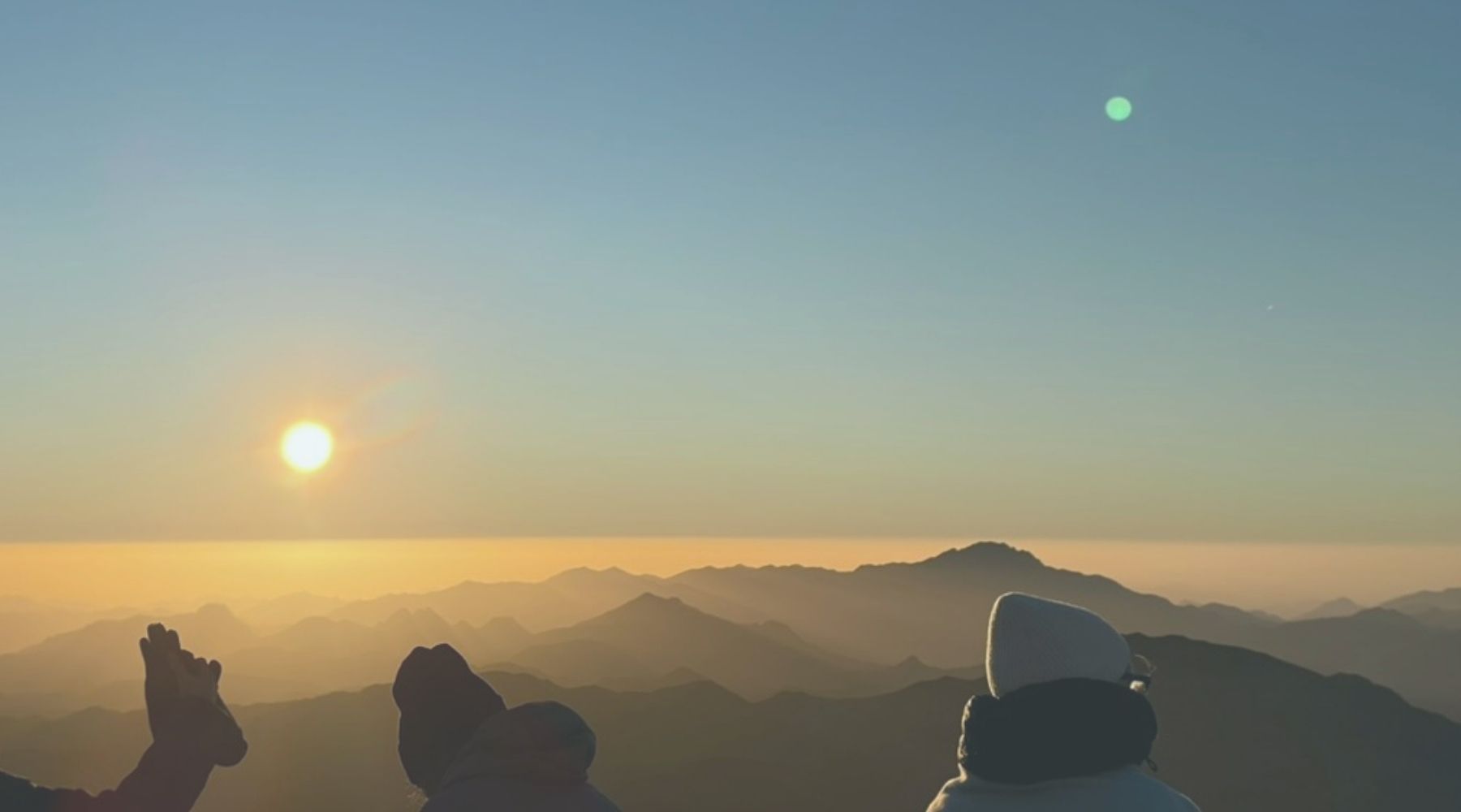 Sunrise over mountains with people enjoying a peaceful outdoor experience, symbolizing the health benefits of nature and outdoor activities