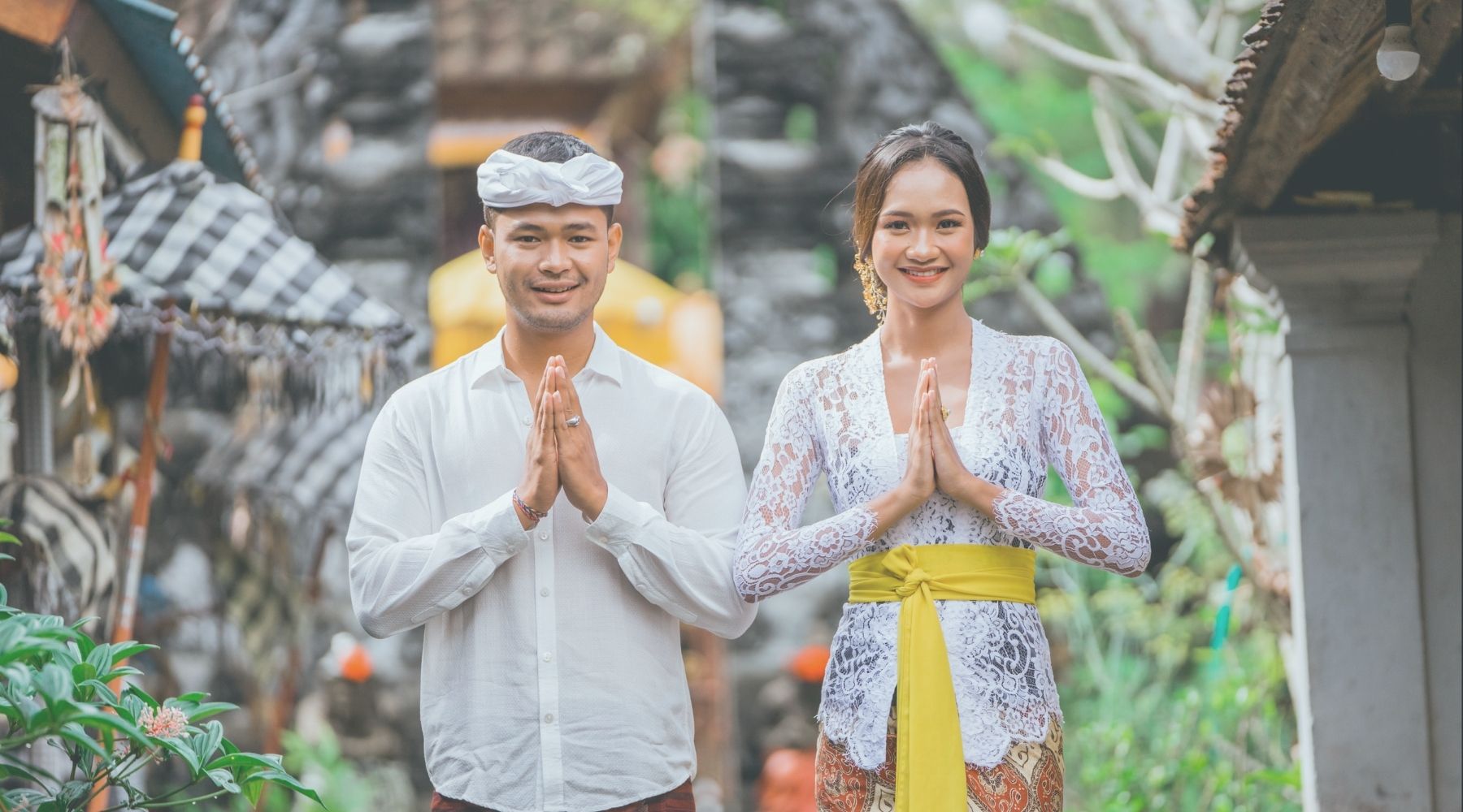 wo people expressing gratitude in traditional attire, reflecting cultural harmony and mindfulness in a serene outdoor setting.