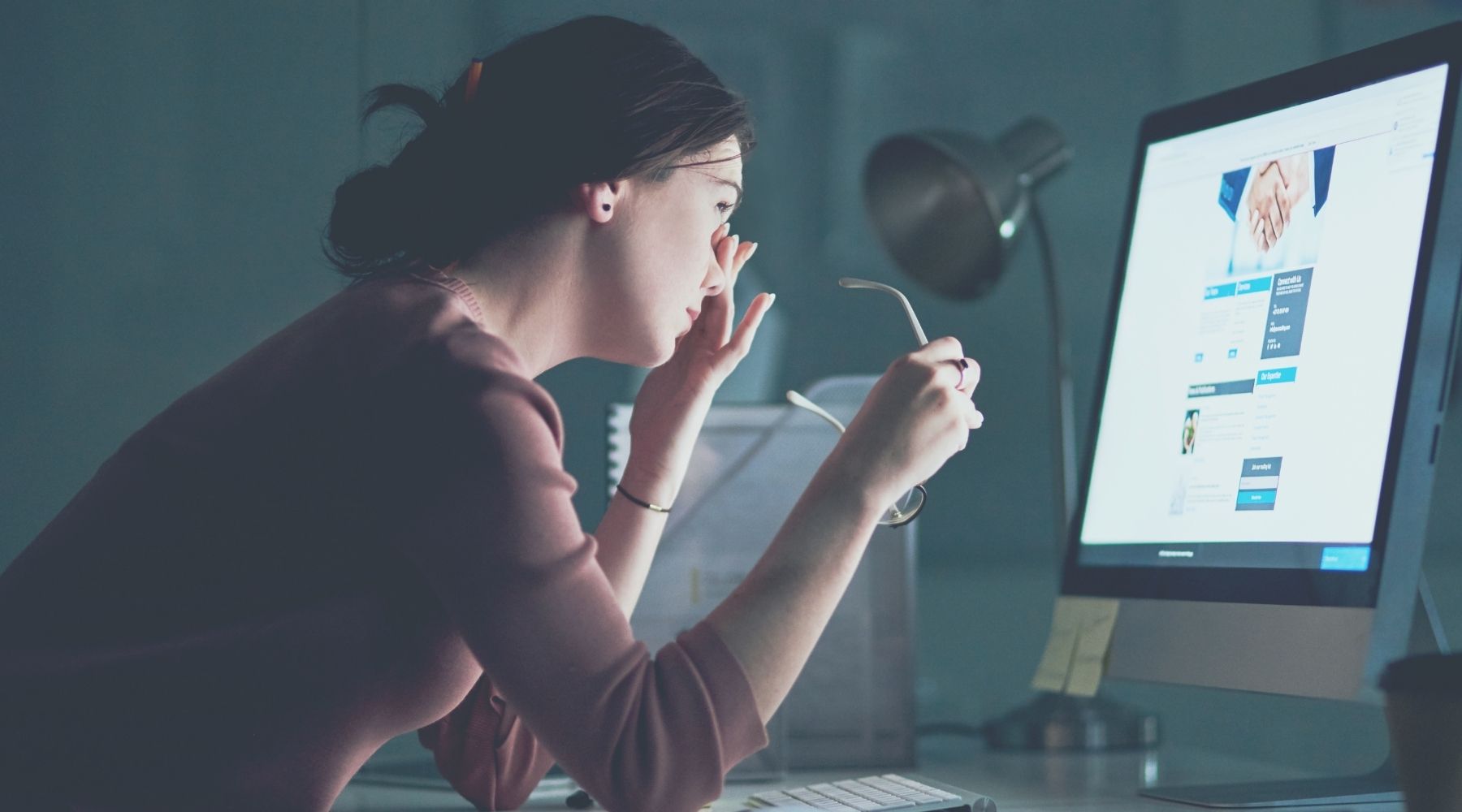 Person experiencing eye strain from prolonged screen time while working at a computer, illustrating the effects of excessive digital exposure and the importance of reducing screen time.