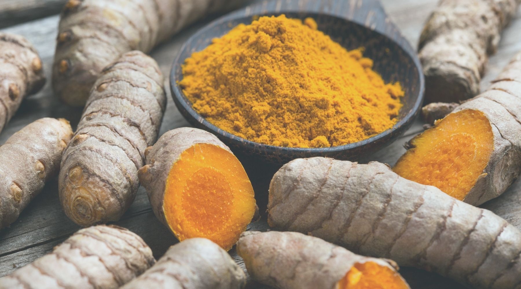 Fresh turmeric roots and powdered turmeric, showcasing the vibrant color and health benefits of this superfood ingredient used in Tonics of Boho’s Original Jamu drink for anti-inflammatory, digestive, and immune-boosting properties.